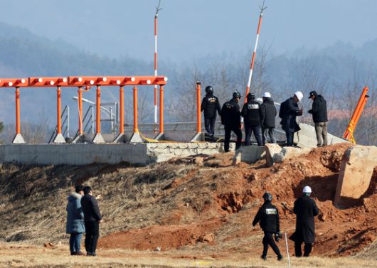 전남 무안국제공항에서 항공철도사고조사위원회, 경찰, 국과수 관계자들과 제주항공 참사 유가족 대표단이 방위각 시설(로컬라이저)을 살펴보고 있다. 연합뉴스