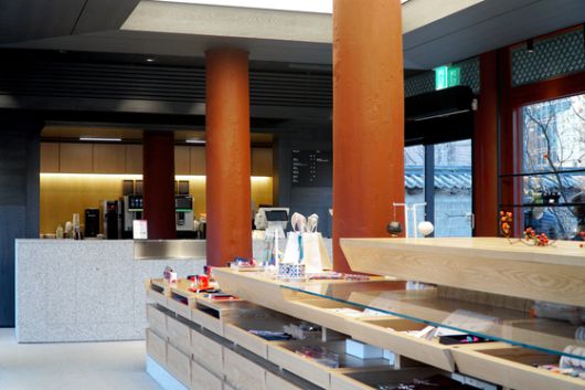 미니멀한 카페 공간과 단차를 활용해 시야에 개방감을 준 진열대. 전통 한옥의 재료인 목재를 사용해 궁궐의 고즈넉함을 표현했다. 사진 국가유산진흥원