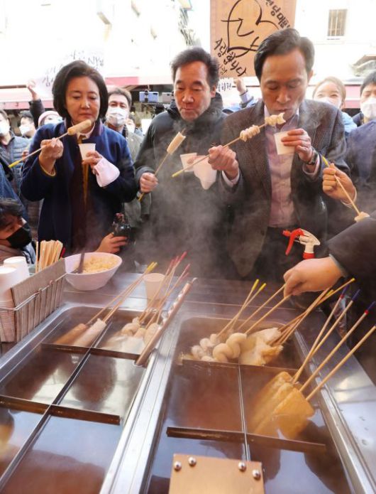이낙연 더불어민주당 대표가 23일 오전 서울 중구 남대문시장에서 서울시장 보궐선거 경선에 나서는 우상호 의원(오른쪽), 박영선 전 중소벤처기업부 장관(왼쪽)과 어묵을 먹고 있다. [이미지출처=연합뉴스]