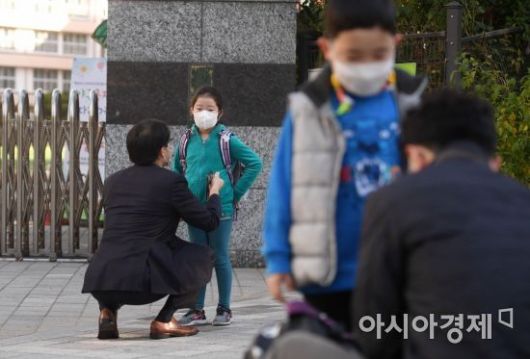 서리가 내린다는 절기 상강(霜降)이자 올가을 가장 쌀쌀한 날씨를 보인 23일 서울 서초구의 한 초등학교 앞에서 부모들이 등교하는 아이들의 옷매무새를 고쳐주고 있다. 기상청은 이날 전국 대부분 지역의 아침 기온이 5도 내외로 떨어지고 낮 기온은 15도 이하에 머물 것으로 예보했다./김현민 기자 kimhyun81@