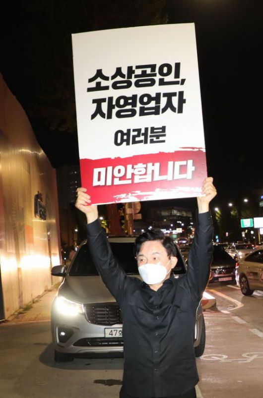 국민의힘 대선경선후보인 원희룡 전 제주도지사가 8일 밤 전국자영업자비대위가 코로나19 방역 지침 수정을 요구하며 전국차량시위를 시작한 원효대교 북단에서 사과 피켓을 들고 있다. [이미지출처=연합뉴스]