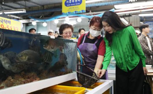 윤석열 대통령 부인 김건희 여사가 14일 부산 기장시장을 찾아 생선 등 수산물을 살펴보고 있다. [이미지출처=연합뉴스]