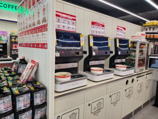 즉석 조리기에서 끓고 있는 라면. 라면을 올려놓고 다른 상품을 구매하려는 소비자들의 모습도 눈에 띄었다. [사진=이민지 기자]