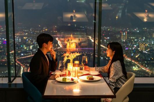 롯데월드타워 전망대 서울스카이 '123라운지'에서 연인이 서울 야경을 배경으로 식사를 하고 있다.[사진제공=롯데월드]
