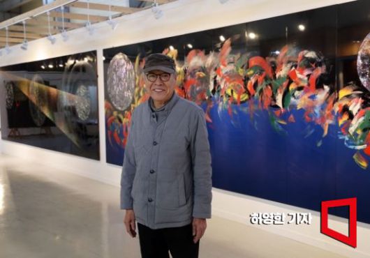 옻칠 장인 전용복이 경기도 안성 전용복 아트스페이스에 걸린 대작들 앞에 섰다. 오른쪽은 연어를 추상해서 그린 '귀향', 왼쪽은 '우주'.  사진=허영한 기자 younghan