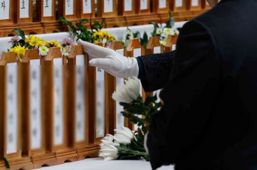 제주항공 여객기 참사로 179명의 사망자가 발생한 가운데 30일 전남 무안국제공항 인근 무안스포츠파크에 희생자 애도를 위해 마련된 합동분향소를 찾은 조문객이 희생자 위패를 만지고 있다. 강진형 기자