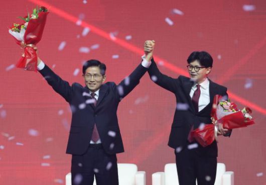 국민의힘 대선 후보로 선출된 김문수 후보가 지난 3일 경기 고양시 킨텍스에서 열린 국민의힘 전당대회에서 꽃다발을 받은 뒤 한동훈 후보와 함께 인사하고 있다. 연합뉴스