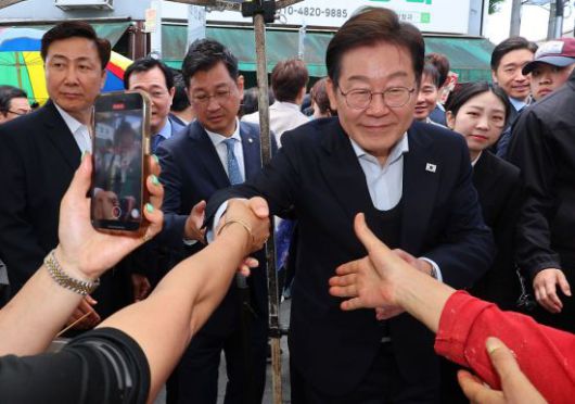 영남 신라벨트 골목골목 경청투어에 나선 더불어민주당 이재명 대선 후보가 지난 10일 경남 함안군 가야전통시장을 찾아 상인들과 인사하고 있다. 연합뉴스