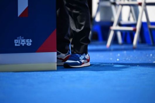 이재명 더불어민주당 대선 후보가 12일 서울 청계광장에서 열린 출정식 및 첫 유세에서 운동화로 갈아신고 있다. 김현민 기자