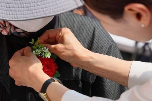 지난 8일 어버이날을 맞아 서울 동대문구 밥퍼나눔운동본부에서 자원봉사자들이 어르신들에게 카네이션을 달아드리고 있다. 윤동주 기자