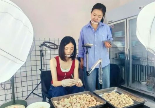 닭고기를 손질하는 영상을 촬영 중인 왕위셴(왼쪽)의 모습. SCMP