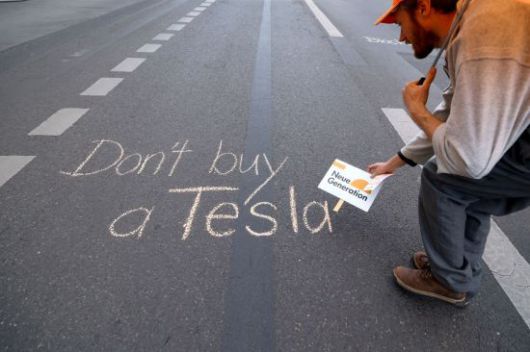 지난 4월30일(현지시간) 독일 베를린의 한 도로에서 테슬라 불매시위를 벌인 한 시민의 모습. 로이터연합뉴스