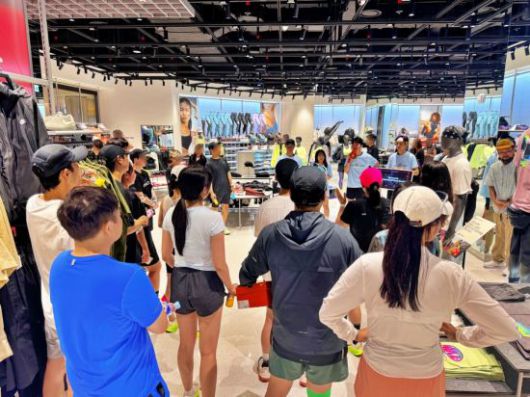 나이키 직원이 러닝 클래스를 마치고 '나이키 라이즈' 매장 내에서 체험한 러너들에게 상품 할인과 사은품 제공 등의 이벤트를 안내하고 있다. [사진제공=롯데백화점]