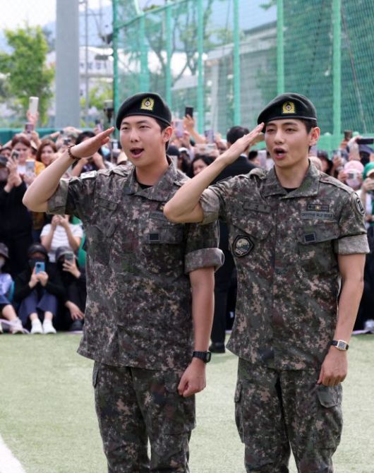 그룹 방탄소년단(BTS) 멤버 뷔와 RM이 10일 강원 춘천시 신북읍 체육공원에서 열린 전역 기념행사에서 팬과 취재진을 향해 경례하고 있다. 연합뉴스
