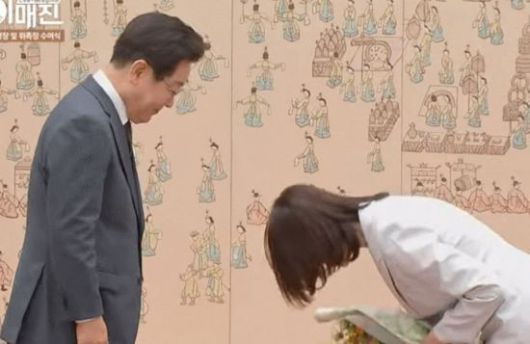 이재명 대통령으로부터 꽃다발을 받은 김민석 국무총리 부인 이태린 여사가 허리 숙여 인사하고 있다. KTV 이매진 캡처