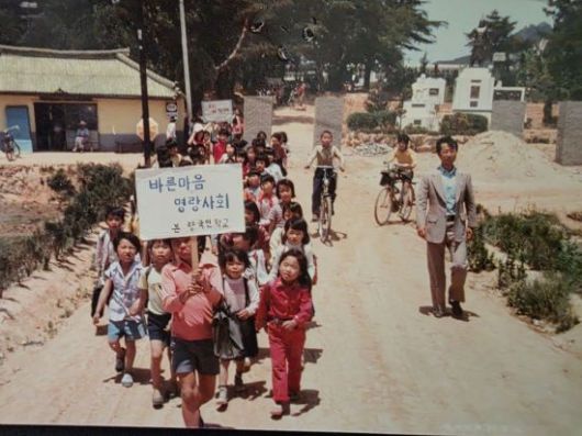 “바른 마음 명랑 사회” 피켓을 앞세운 본량국민학교 학생들의 단체 등교 장면. 본량초 제공