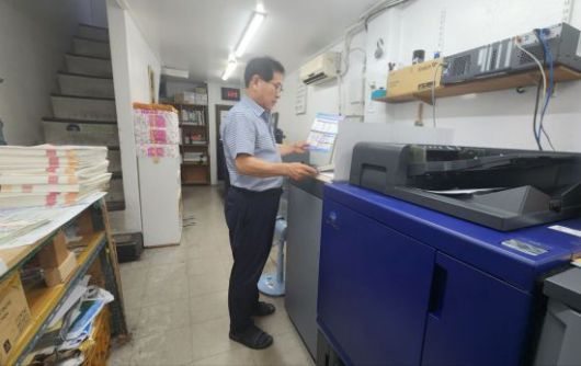 서울 충무로 인쇄골목에서 인쇄소를 운영하고 있는 이해욱씨가 출력물을 검수하고 있다. 변선진 기자