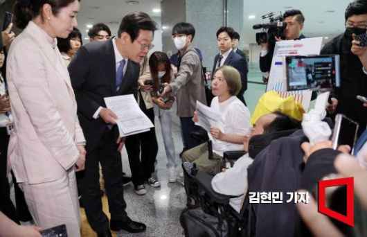 이재명 더불어민주당 대표가 2023년 국회 의원회관에서 열린 토론회에 참석하던 중 전국장애인차별철폐연대(전장연) 관계자들을 만나 장애인복지법 관련 건의사항을 듣고 있다. 사진=김현민 기자 kimhyun81@