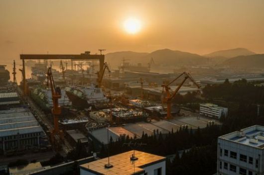 경남 거제 한화오션 옥포조선소 야드 도크에서 건조중인 액화천연가스(LNG) 운반선 위로 붉은 태양이 떠오르고 있다. 강진형 기자