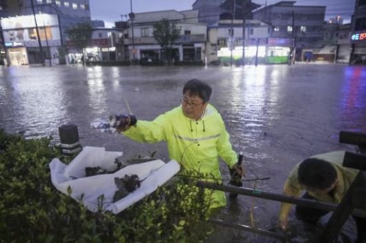 강기정 광주시장이 17일 오후 폭우로 침수된 북구 신안교 일대를 돌며 배수로를 막은 플라스틱, 비닐 등의 쓰레기를 직접 치우고 배수 상황을 점검하고 있다. 광주시 제공