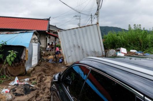집중호우로 가평군 일대가 큰 피해를 입은 가운데 21일 경기 가평군 상면 조종천에 인접한 대보1리 마을 입구에 급류로 떠내려온 컨테이너가 길목을 막고 있다.
