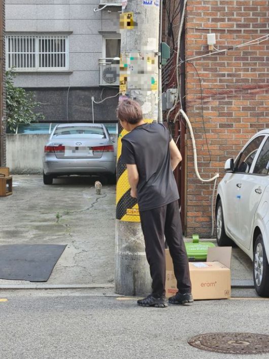 지난 7일 길고양이 포획자가 고양이의 관심을 끌고 있다. 박승욱 기자