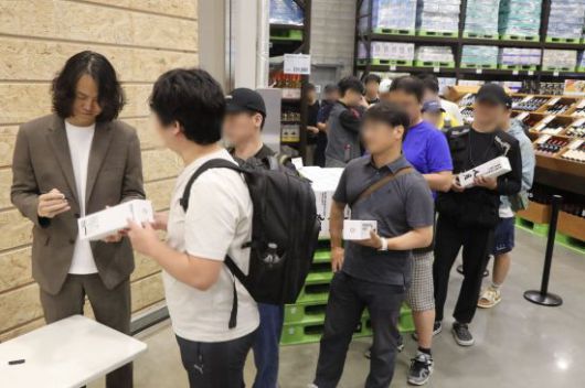 5일 오전 트레이더스 구월점에서 한정수량 판매된 '김창수 위스키'를 구매 중인 고객들과 사인 중인 김창수 대표의 모습. 이마트 제공