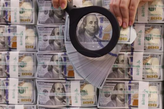 서울 중구 명동 KEB하나은행 위변조대응센터에서 직원이 미국 달러를 들어 보이고 있다. 연합뉴스