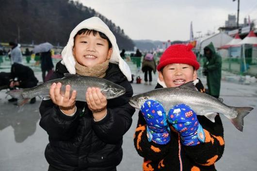 10일 개막한 2026 화천산천어축제 현장을 찾은 어린이들이 낚시로 잡은 산천어를 들어보이고 있다. 화천군 제공