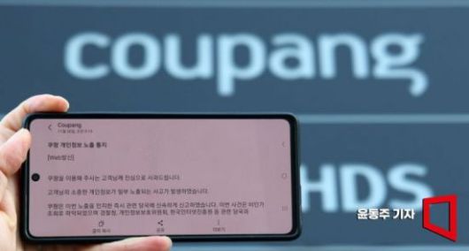 지난달 1일 개인정보 유출 사고와 관련한 쿠팡 사과 문자 뒤로 쿠팡 본사에 설치된 쿠팡 입간판이 보이고 있다.