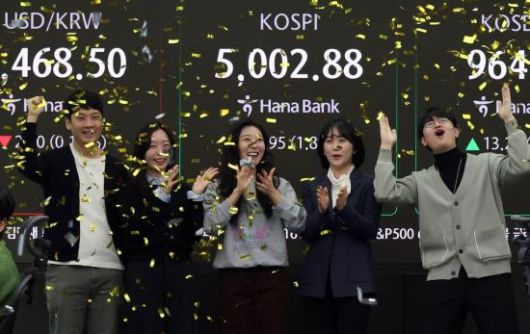 코스피가 꿈의 지수 '5000'을 돌파한 22일 서울 중구 하나은행 딜링룸에서 직원들이 기뻐하며 박수를 치고 있다. 조용준 기자