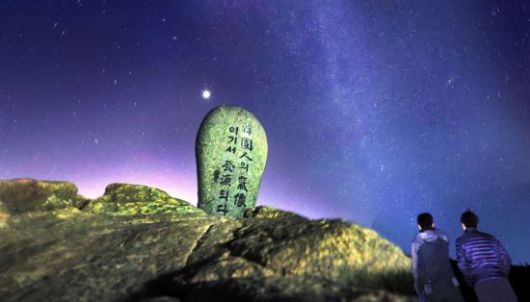 장터목대피소에서 천왕봉 위로 내려 앉은 은하수를 보는 탐방객.(천왕봉 표지석과 레이어합성)