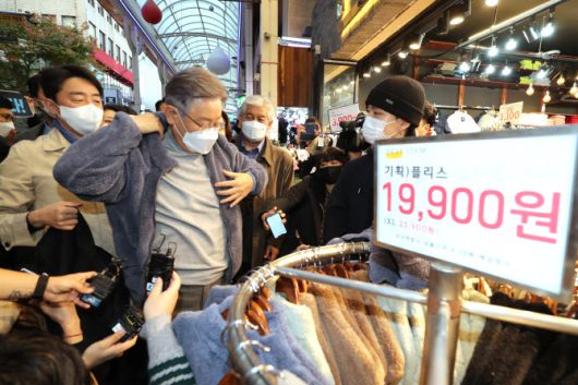 이재명 더불어민주당 대선 후보가 12일 오후 울산시 중구 울산중앙전통시장을 방문, 판매 중인 옷을 직접 입어보고 있다. (사진=연합뉴스)