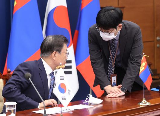 문재인 대통령이 10일 청와대 영상회의실에서 우흐나 후렐수흐 몽골 대통령과 화상 정상회담을 앞두고 탁현민 의전비서관과 대화하고 있다. 연합뉴스