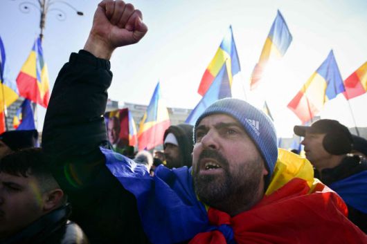 10일(현지시간) 부쿠레슈티의 루마니아 정부 청사 앞에서 극우 정치인 컬린 제오르제스쿠 대통령 후보 지지자들이 시위를 벌이고 있다.(사진=AFP)