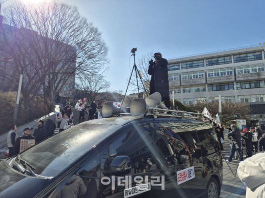 17일 오전 서울 관악구 서울대 캠퍼스에서 한 유튜버가 차 위에 올라타 윤 대통령 탄핵 찬반 집회 현장을 중계하고 있다. (사진=정윤지 기자)