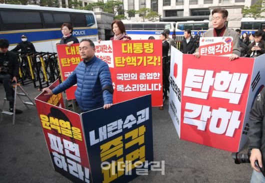 지난 24일 오전 서울 종로구 재동 헌법재판소 앞에서 김정재(뒤쪽 왼쪽부터), 김미애 국민의힘 의원이 윤석열 대통령 탄핵에 반대하는 피켓을 들고 있다. 앞쪽은 윤 대통령 탄핵을 촉구하는 김원이 더불어민주당 의원. (사진=이데일리 이영훈 기자)