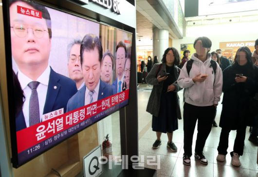 [이데일리 김태형 기자] 4일 오전 11시 서울 중구 서울역 대합실에서 시민들이 윤석열 전 대통령 탄핵심판 선고 TV 생중계를 보고 있다.