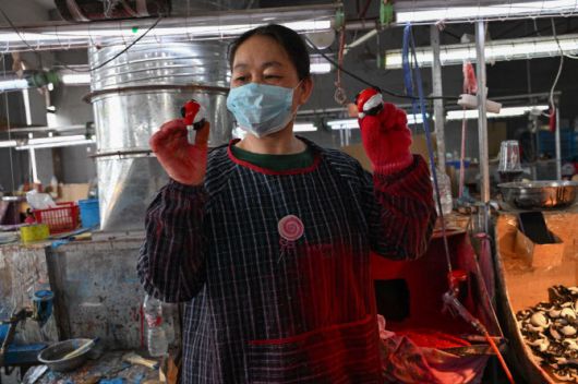 중국 저장성 이우의 플라스틱 제조 공장에서 직원이 장난감 제품을 보여주고 있다. (사진=AFP)