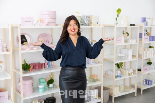 정새라 대표가 미국에 진출한 K뷰티 브랜드 제품 앞에서 포즈를 취하고 있다.(사진=랜딩인터내셔널)
