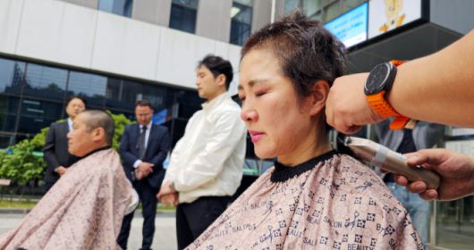 제주대 미래융합대학 김상미(오른쪽) 교수와 이호진 교수가 23일 오후 총장실이 있는 산학협력단 건물 입구에서 성인 학습자 평생학습권 보장 등을 촉구하며 삭발하고 있다. 사진=연합뉴스