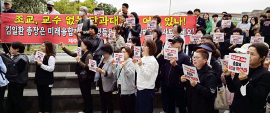 제주대 미래융합대학 교수와 학생들이  23일 오후 총장실이 있는 산학협력단 건물 입구에서 교수 삭발식을 하고 나서 성인 학습자 평생학습권 보장 등을 촉구하는 구호를 외치고 있다. 사진=연합뉴스