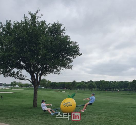 꼬마들이 ‘스퀴즈 더 데이’가 쓰여 있는 레몬 모양의 시소를 타며 놀고 있다.