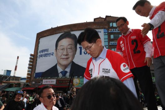국민의힘 김문수 대선 후보가 14일 경남 밀양시 밀양관아 앞에서 유세하고 있다. 이재명 더불어민주당 대선 후보 대형 현수막이 밀양관아 맞은편 건물 외벽을 다 채웠다. 사진=연합뉴스