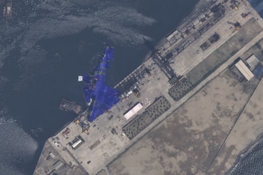 에어버스 DS가 지난 22일 촬영한 북한 청진조선소 위성 이미지다. 진수에 실패한 북한의 신형 구축함이 전복된 채 파란색 방수포로 덮여 있다. (출처=AP)