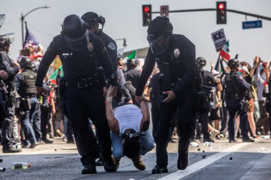 캘리포니아주 로스앤젤레스의 LA 연방청사 앞에서 로스앤젤레스 경찰국(LAPD) 경찰관들이 시위대를 체포하고 있다. 트럼프 행정부가 시 당국의 반대에도 불구하고 이민 단속 작전 중 경찰과 시위대 간의 이틀간 충돌 이후 주방위군을 동원하자, 도시 내 긴장감이 고조되고 있다. (사진=AFP)