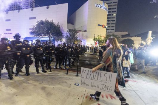 9일(현지시간) 로스앤젤레스에서 한 시위자가 ‘해병대, 1월 6일엔 어디있었나’라는 팻말을 들고 경찰과 대치하고 있다. 1월 6일은 2021년 1월 6일 2020년 도널드 트럼프 당시 미국 전 대통령의 대선패배에 불복한 시위자들이 미국 국회의사당 습격사건을 의미한다. (사진=AFP)