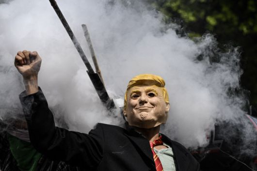 로스앤젤레스(LA) 시청 앞에서 열린 14일(현지시간) ‘노킹스’ 시위에서 한 시민이 도널드 트럼프 대통령 가면을 쓰고 있다. (사진=AFP)