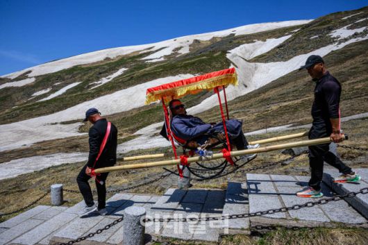 지난 12일 백두산 천지 서파지역에서 가마꾼이 손님을 태우고 이동하고 있다.