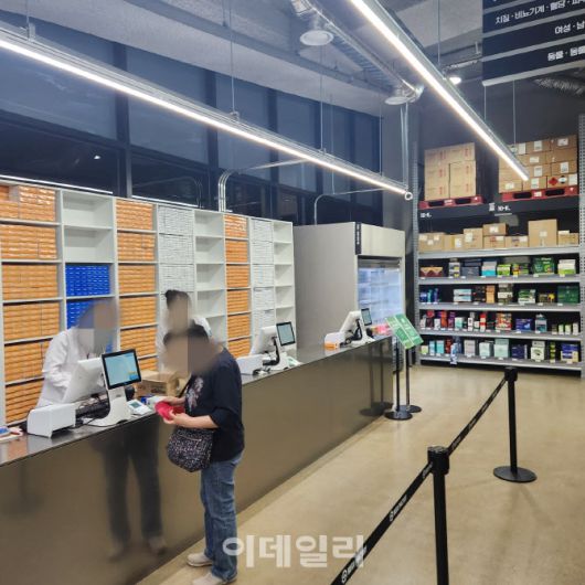 A약국 내 흰 가운을 입은 약사가 계산대에서 복약지도도 하고 매대를 구경하는 손님에게 직접 찾아가 상담도 진행해 바쁜 모습이었다. (사진=안치영 기자)